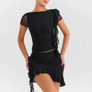 Detail of black two-piece set featuring sheer mesh panels and layered ruffle textures
