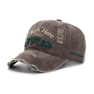 Détail d'une casquette baseball marron délavé avec broderie 3D et bords usés vintage