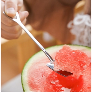 Stainless steel shovel spoon scooping fresh watermelon flesh in a lifestyle setting