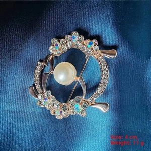 Detail of camellia flower brooch with white pearls and AB crystals on blue satin