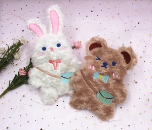 Détail de trousses en peluche d'ours et lapin avec broderies mignonnes et douces