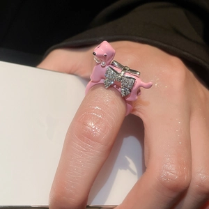 Close-up of pink enamel dachshund ring with zircon bow and pearl collar detail