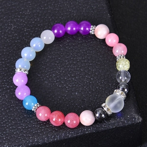 Detailed macro view of colorful natural stone beads and silver diamond-set spacers on a bracelet