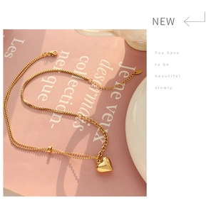 Detail of gold titanium heart pendant necklace with double-layer snake and link chain