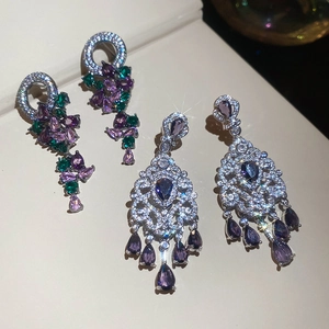 Detailed close-up of zircon drop tassel earrings with sparkling purple and green gems