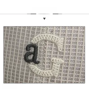 Détail macro du tissu en maille respirante avec broderie en relief des lettres aG