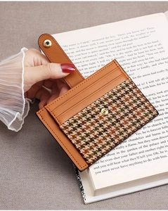 Detail of slim brown houndstooth leather card holder with snap button and card slots