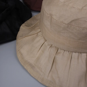 Detail of elegant ruffled brim and breathable linen texture on women's summer sun hat