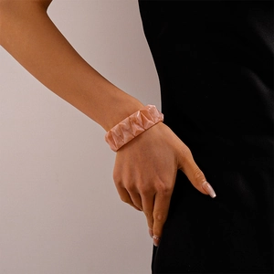 Detail of pink marble textured acrylic geometric bracelet on a model's wrist