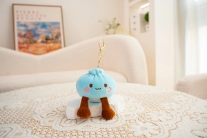 Macro view of blue steamed bun plush keychain with cute embroidery and gold clip