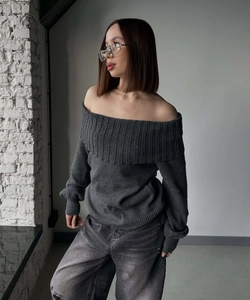 Close-up of dark grey off-shoulder sweater with vertical ribbed texture and grey jeans