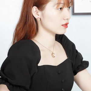 Gros plan d'un ensemble de bijoux élégants en or rose avec étoile et perle sur un modèle