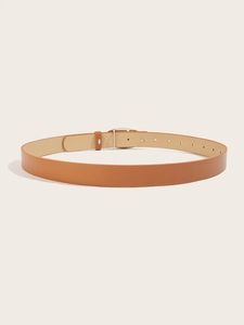 Close-up of tan leather belt with silver heart buckle and pre-punched holes for women