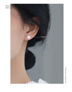 Detailed view of 8mm round white pearl stud earring worn on a classic lace collar
