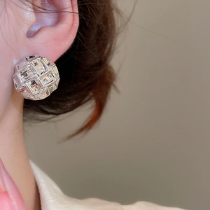 Detailed view of silver geometric grid sphere stud earring with a polished metallic finish