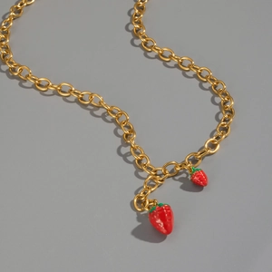 Detailed view of 18K gold plated chain with red enamel strawberry charms on a gray base