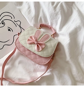 Detail of pink and white quilted PU leather handbag with rabbit ears and a bow