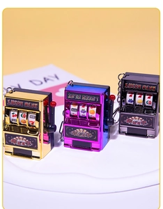 Three mini fruit slot machine keychains in gold, purple and black finishes with lucky charms