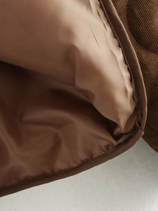 Detailopname van bruine corduroy jas met gladde polyester voering en hoogwaardige textuur