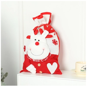 Detail of red knitted Christmas gift bag with reindeer motif and snowflake patches