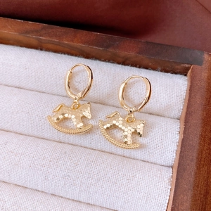 Détail de boucles d'oreilles cheval à bascule plaqué or 18k avec texture en nid d'abeille