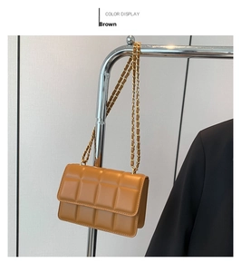 Detailed view of brown quilted crossbody bag with gold chain strap and checkerboard pattern