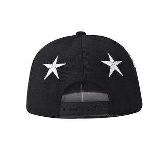 Detail of white star embroidery on the back of a black cotton snapback baseball cap