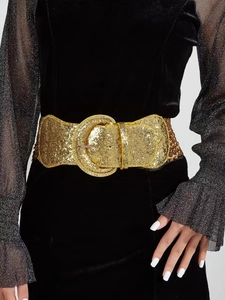 Detail of a wide gold sequined belt with a large round buckle on a black velvet dress