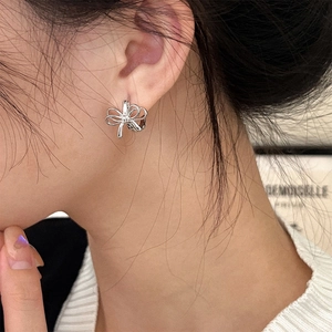 Minimalist silver bow earrings worn by model for an elegant and sophisticated look