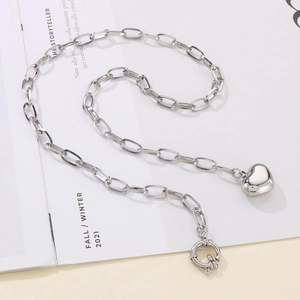 Detailed close-up of a silver chunky chain necklace with heart pendant and OT buckle