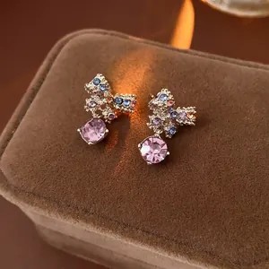 Golden bow earrings with colorful rhinestones and pink crystal drop on velvet box