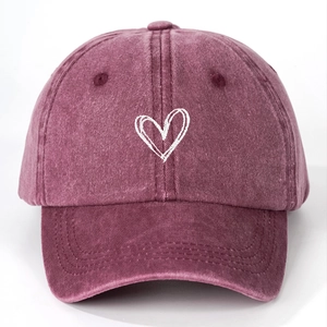 Macro detail of white heart embroidery on washed cotton canvas baseball cap
