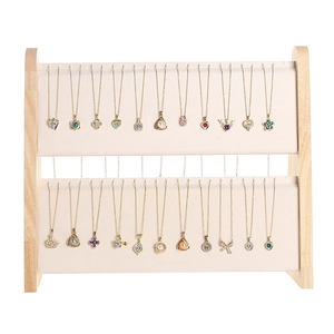 Two-tier beige velvet jewelry stand with wooden frame displaying multiple gold necklaces