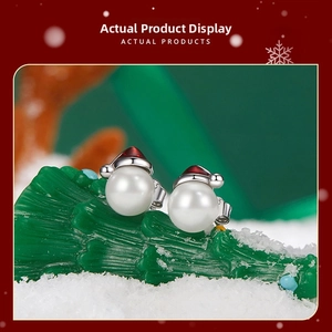 Detail of s925 silver snowman pearl earrings with red Christmas hat for holiday gifts
