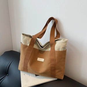 Minimalist canvas tote bag with brown and beige splicing in a stylish interior setting