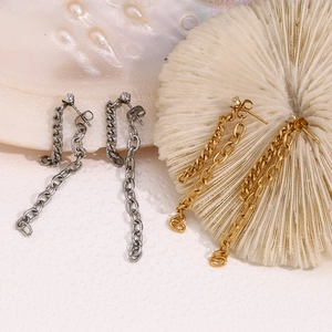 Macro shot of 18K gold and silver chain earrings with zircon on shells and coral