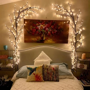 Close-up of warm white LED branch lights creating a cozy bedroom ambiance over the bed