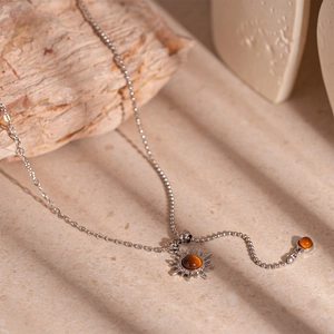Retro sunflower pendant necklace with tiger eye stone on elegant beige stone background