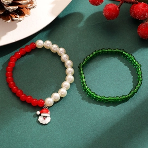 Gros plan de bracelets de Noël perlés avec pendentif Père Noël et décorations de fêtes