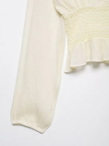 Detail of smocked waist and delicate lace texture on this cream chiffon blouse for women