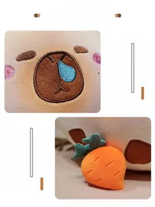 Gros plan d'une peluche capybara avec broderie faciale et accessoire de carotte