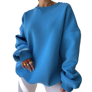 Detailed shot of sky blue knitted sweatshirt showing ribbed cuffs and white logo embroidery