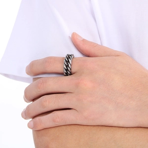 Close-up of a silver titanium steel Cuban chain ring worn on a finger for a bold style