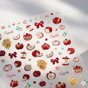 Détail macro de stickers ongles 3D en relief motif pomme et nœud, texture mate