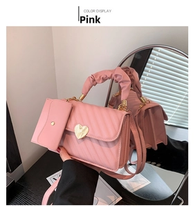 Pink quilted handbag set with heart gold buckle and ruched handle shown in mirror