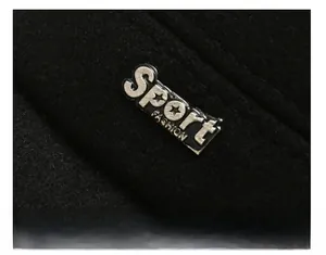 Macro detail of sport fashion metal emblem on thick black wool winter flat cap