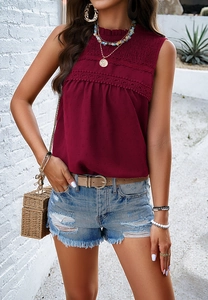 Detail view of wine red sleeveless blouse with lace trim and pleated texture design