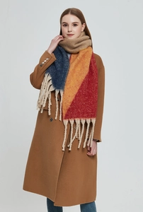 Detail of soft multi-color block scarf with thick tassels and brushed texture on model