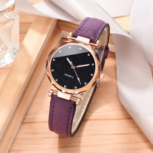 Detail of starry dial women's watch with purple strap and faceted glass on wood surface