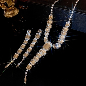 Detailed view of luxury silver necklace and square fringe earrings with crystal accents